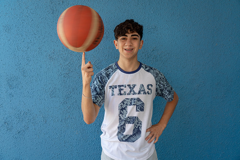 Maximiliano smiling and balancing a basketball after cleft surgery