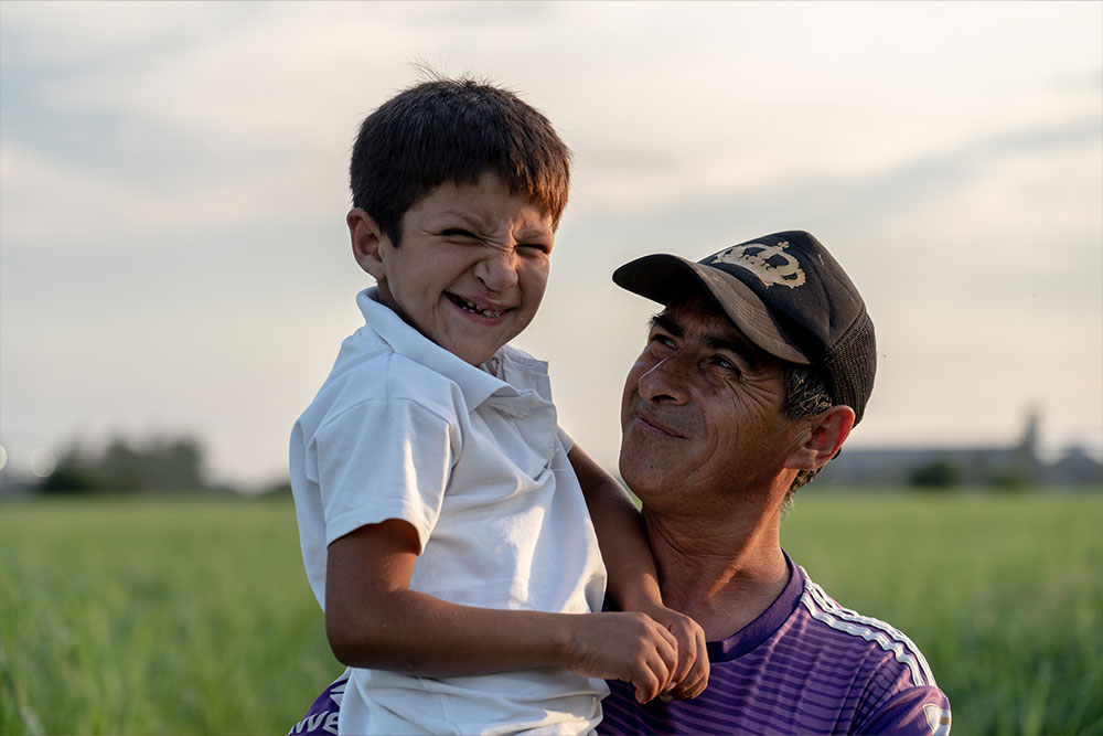 Samir smiling and hugging his adoptive father Daniel