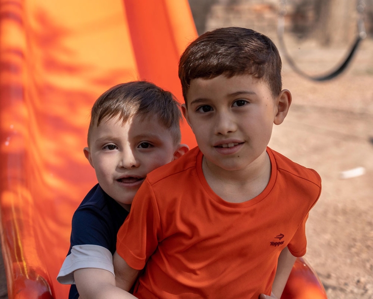 Edden going down a slide with his brother after cleft surgery